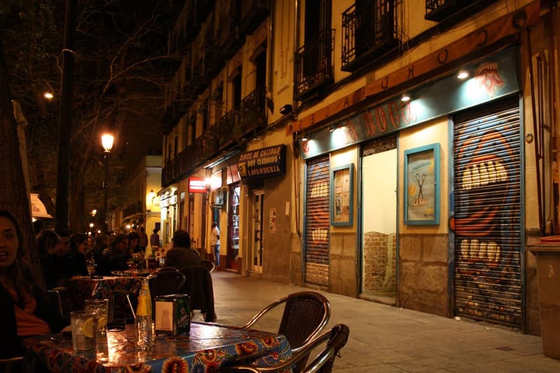 Calle de Argumosa in Lavapies, Madrid, a tree-lined street with terrace tables outside its bars